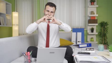 Happy-and-positive-young-businessman-makes-heart-symbol.